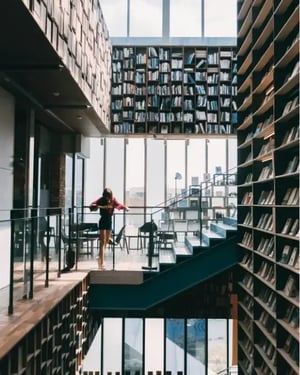 woman-looking-over-a-balcony-in-a-library